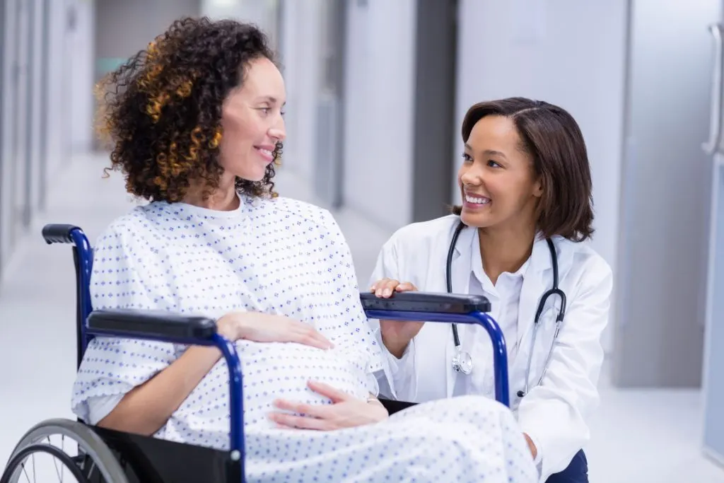 Online 12 Month Family Nurse Practitioner Programs - FNP doctor with woman